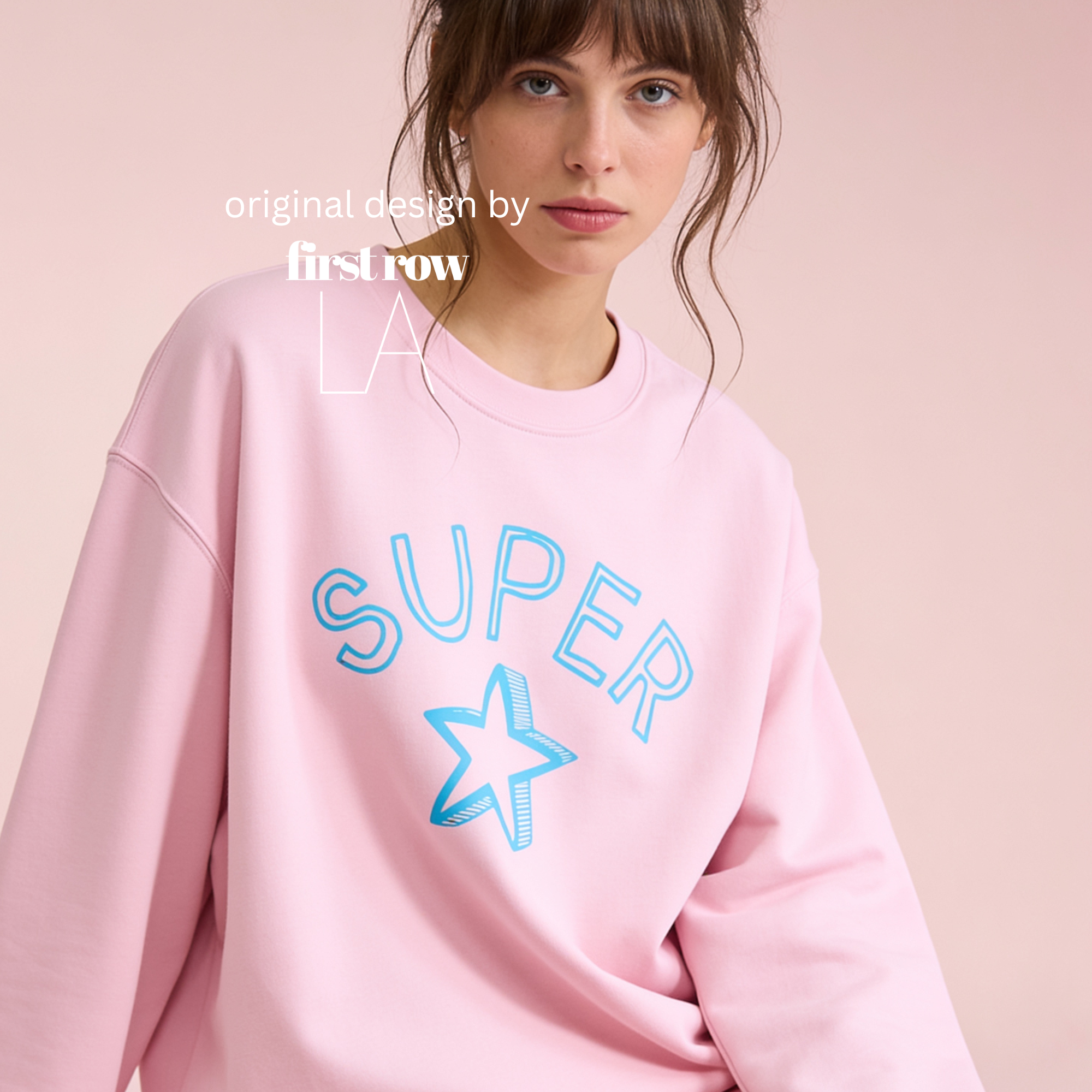 A woman wearing a light pink crewneck sweatshirt with 'SUPER' and a star outlined in blue on the front.

Original design and copyright by first row LA.
