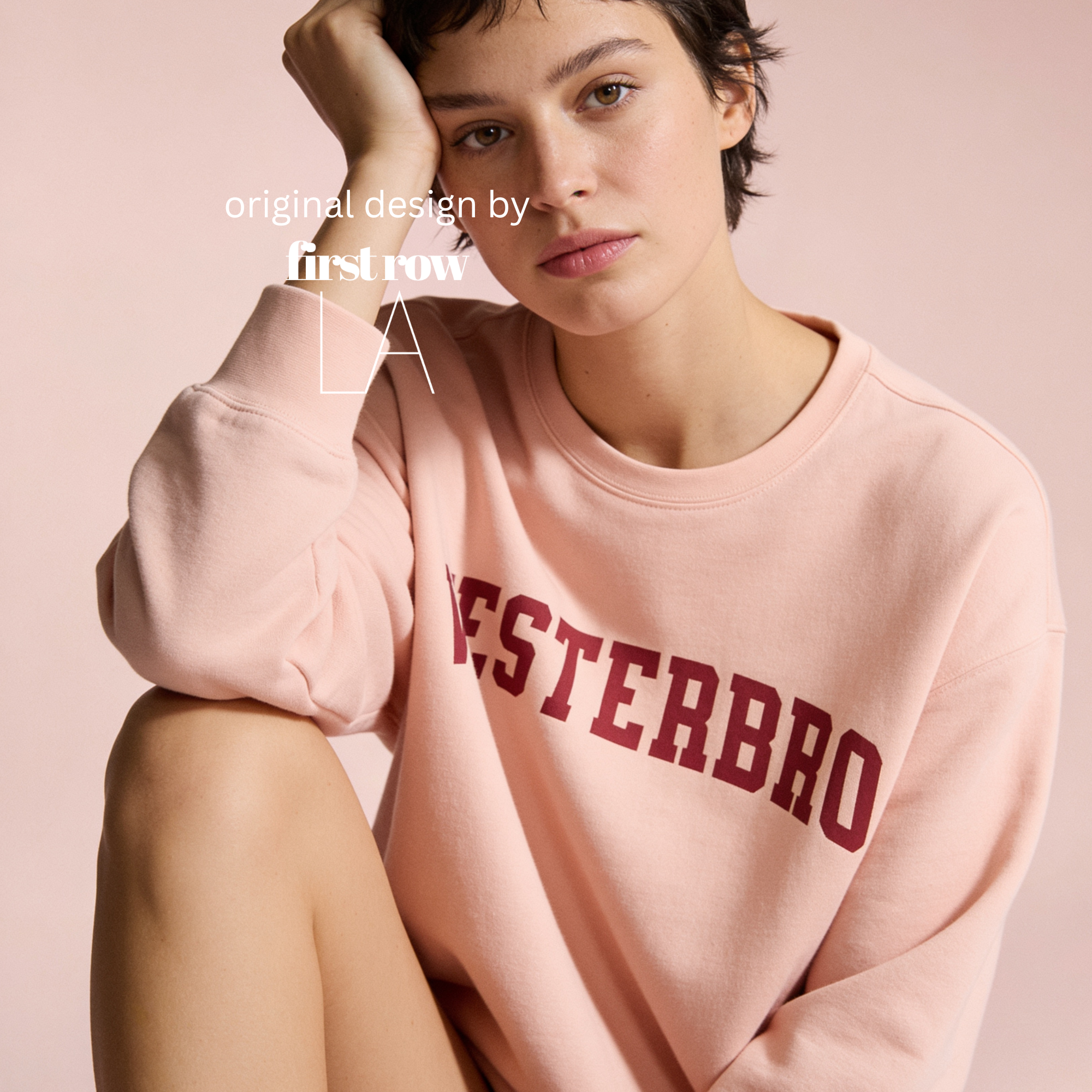 Woman wearing a light pink crewneck sweatshirt with 'VESTERBRO' printed in dark red collegiate letters across the chest.

Original design and copyright by first row LA.