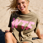 A woman wearing a khaki oversized T-shirt with large pink 'WTF' print.

Original design and copyright by first row LA 2026.