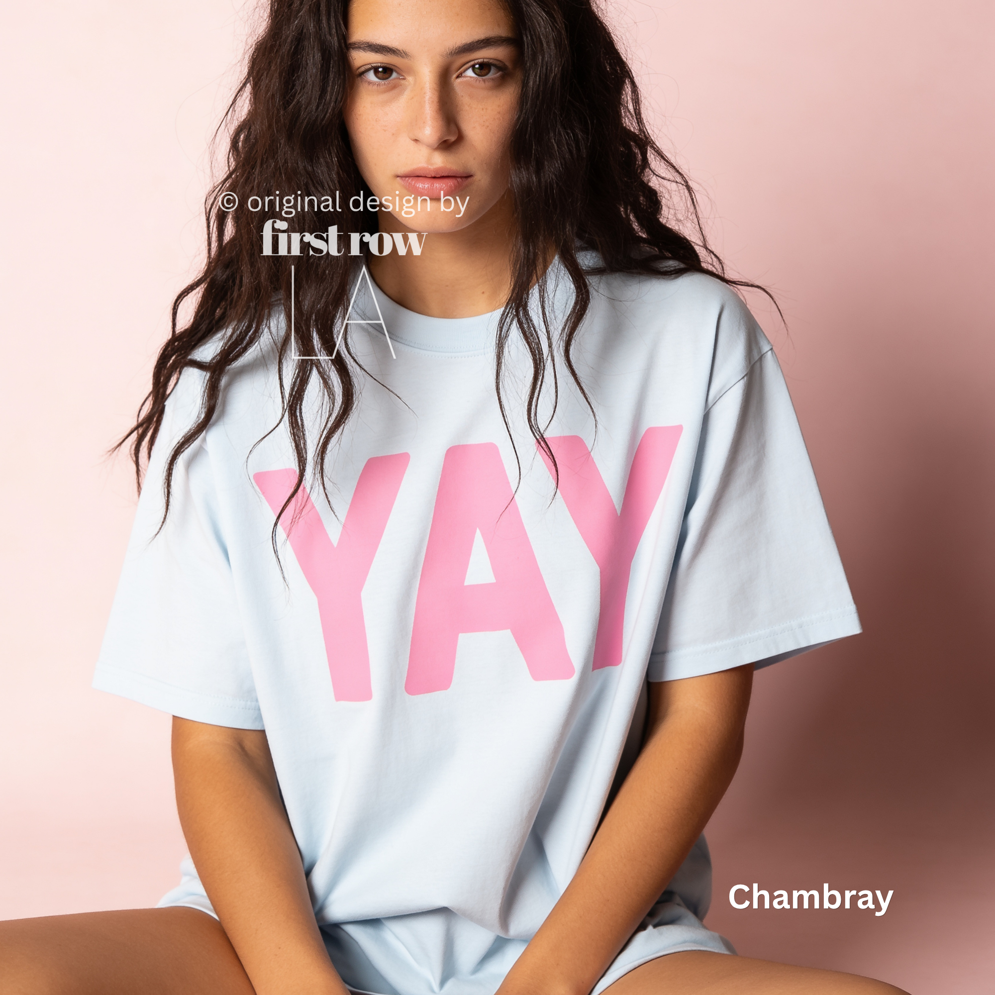 A woman wearing a light blue t-shirt with pink YAY print.

Original design and copyright by first row LA 2026