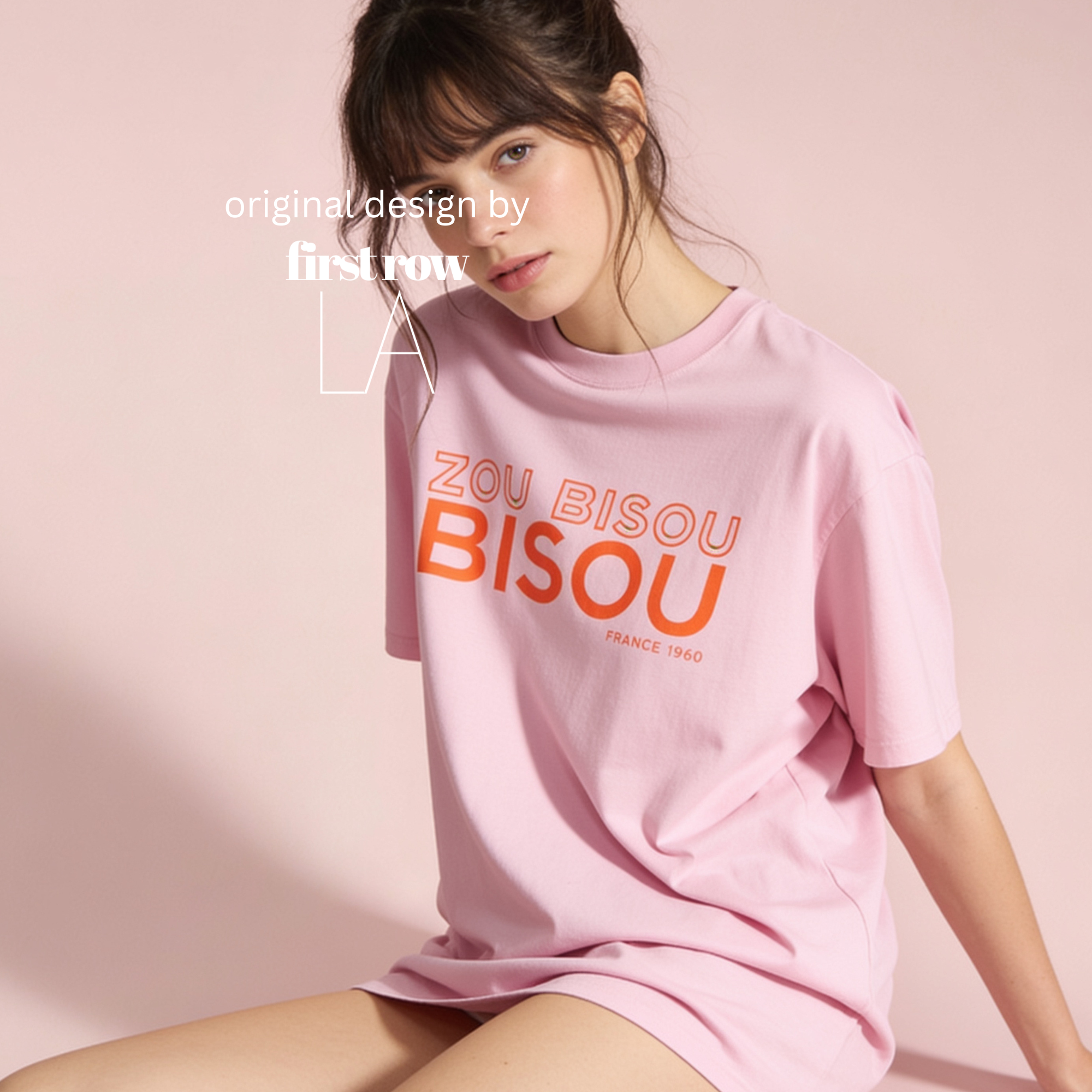 A woman wearing an oversized light pink T-shirt with orange and white text reading 'ZOU BISOU BISOU, France 1960' 

Original design and copyright by first row LA.